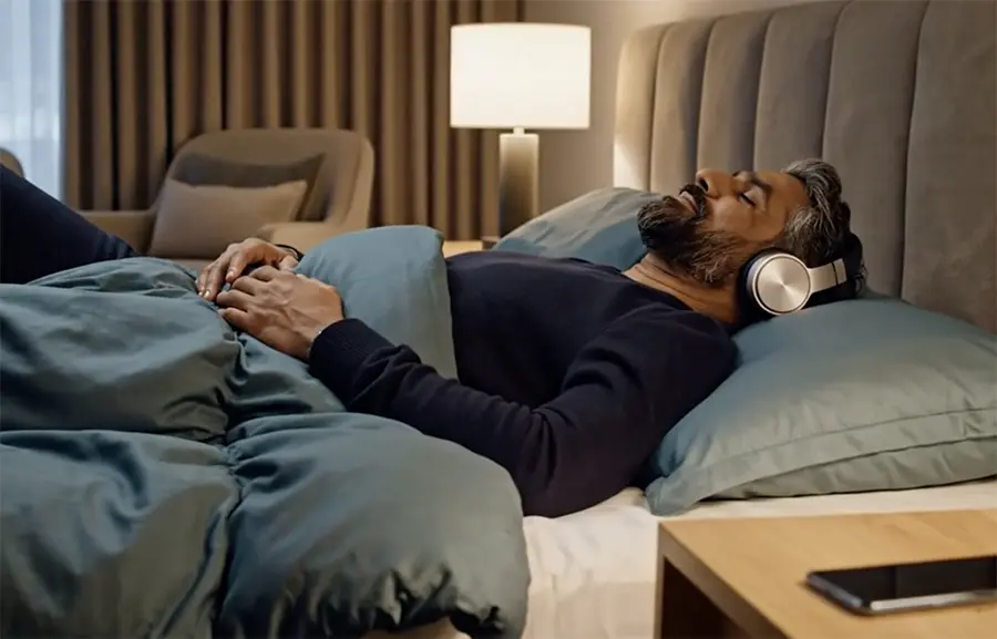 Man on bed listening to audio hypnotherapy